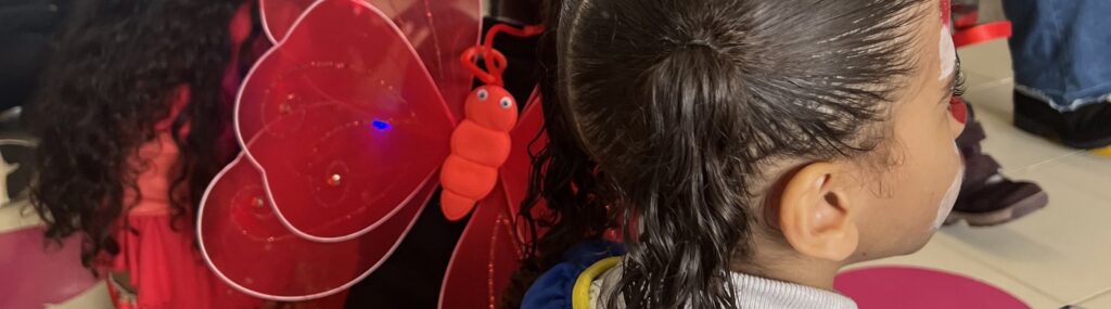 Borboleta no cabelo e criança com cara pintada